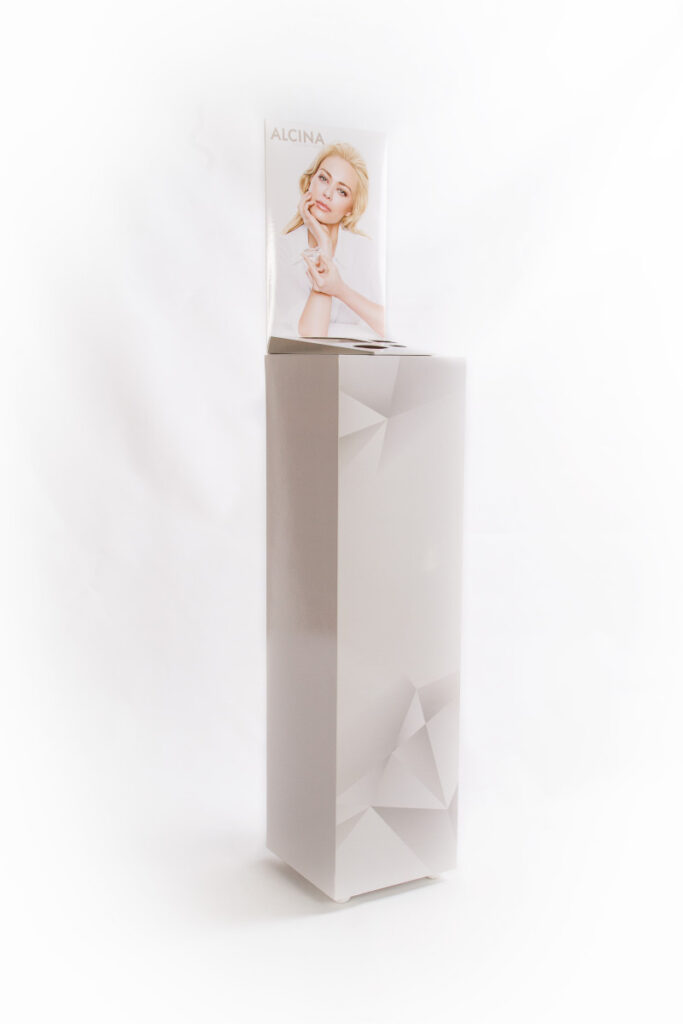 Beispiel eines Bodenaufstellers mit grauem Sockel und Foto einer weiblichen Person hinter der für das Produkt vorgesehenen Fläche.