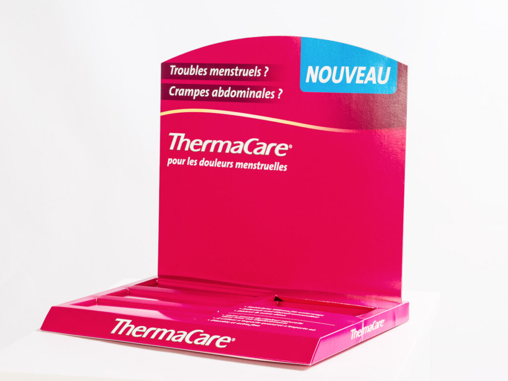 Beispiel für ein Thekendisplay, bestehend aus einer bedruckten Rückwand und einem flachen Sockel mit Aussparungen für die Produktplatzierung.