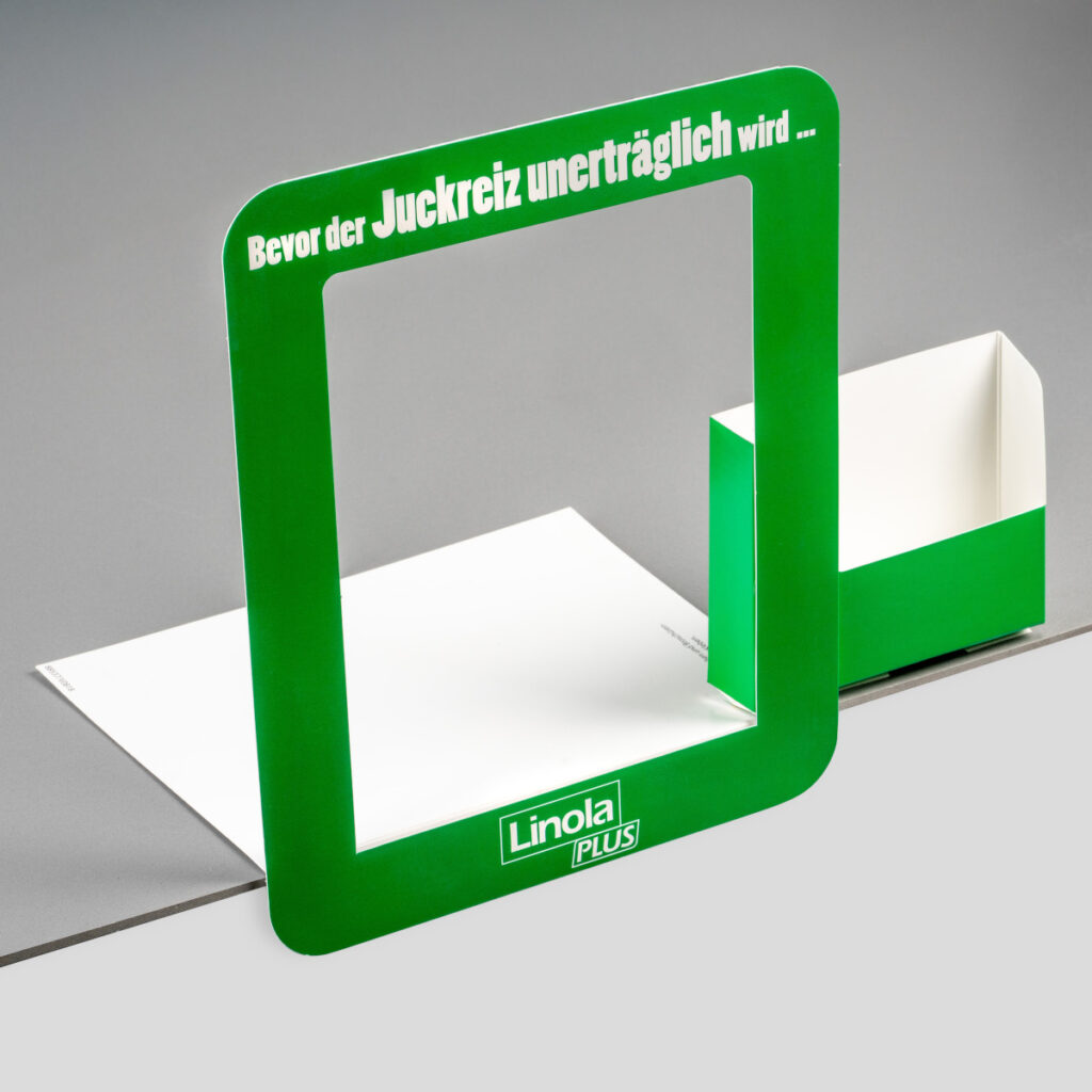 Beispiel für eine Regalschiene zur Dekoration. Die Regalschiene bildet einen Rahmen um das Produkt, zusätzlich ist eine Box für Flyer etc. angehängt.