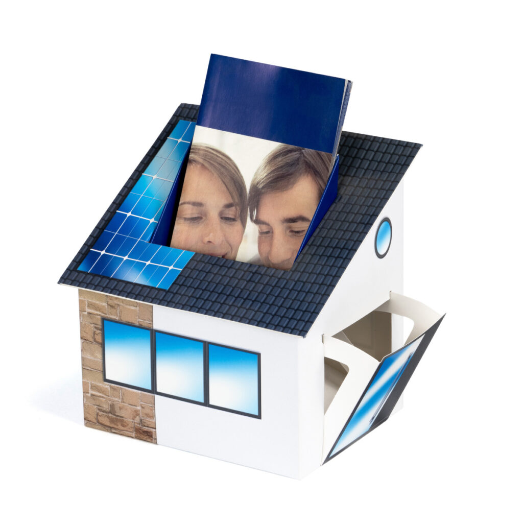 Beispiel eines Thekendisplays in Form eines Gebäudes. Nachgebildet/aufgedruckt sind Dach, Fenster und Türen. Die Oberseite bildet ein Fach für Flyer.