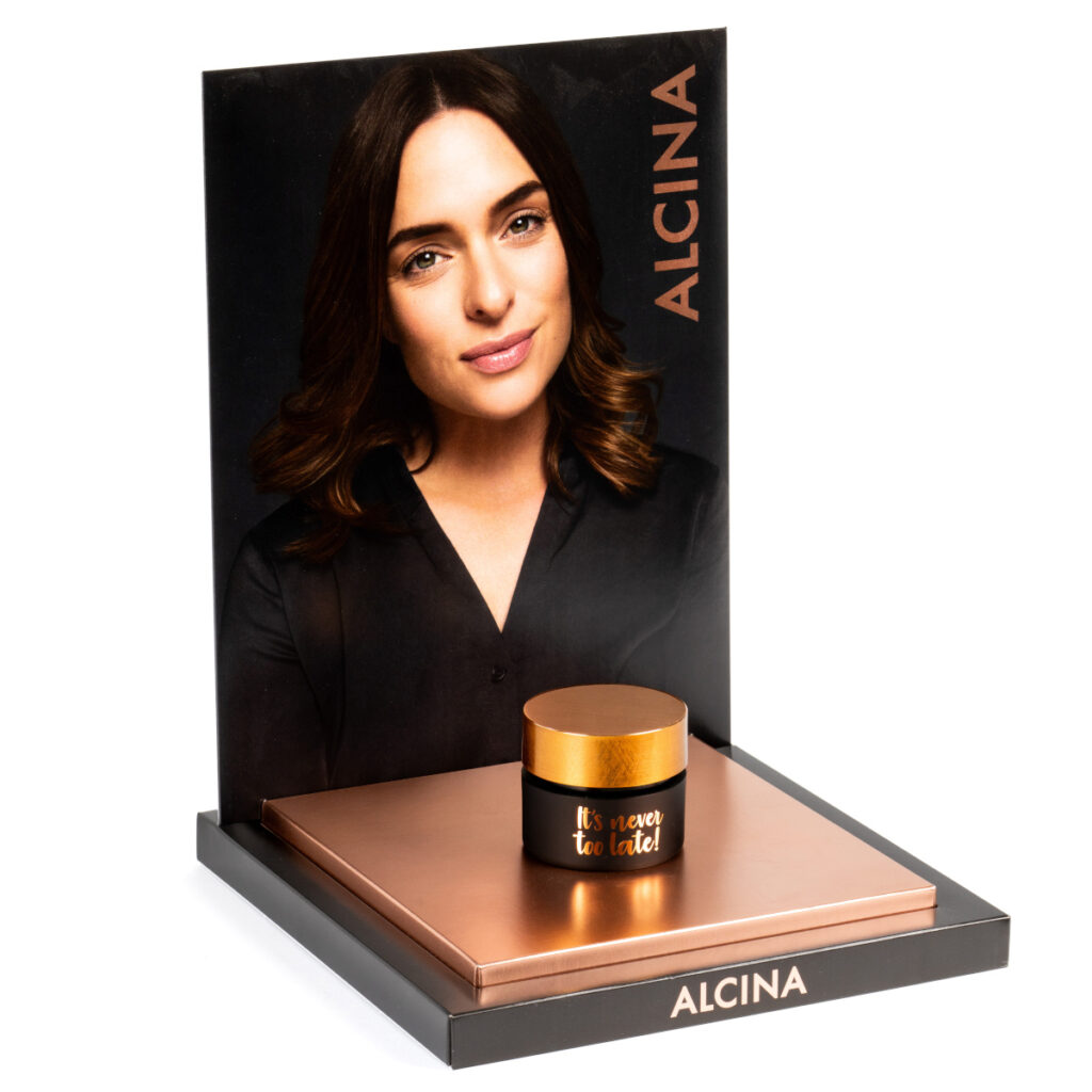 Beispiel für ein Thekendisplay, bei dem ein einzelner Salbentiegel auf einem Podest präsentiert wird.